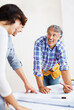 © Stigur/peopleimages.com - Teamwork, architect and couple explaining blueprint for construction, sketch and planning in new home. Smile, architecture and happy people with design for renovation contractor, building and project