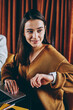 © BullRun - Two successful female freelancers working remotely on laptop devices sitting at table in coffee shop, positive hipster girl checking time and message on electronic smartwatch spending time with friend