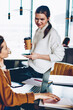 © BullRun - Positive female students communicated in break of e learning enjoying coffee break at cafeteria, successful persons sitting at coworking space using technology at wireless internet for reading news