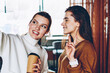 © BullRun - Positive hipster girl taking picture with friend using application for blogging via cellular phone, successful women making selfie photo via web camera on smartphone spending time at coffee shop