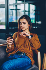 Wall Mural - concentrated female teenager making payment via application for transaction using mobile phone with 