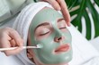 © Moopingz - A woman enjoys a relaxing facial mask treatment at a spa, promoting skincare and relaxation in a serene environment.