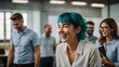© Hashim - Teal-haired woman in office team building, laughing and relaxed with blur colleagues