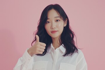 Poster - A woman with long hair is giving a thumbs up. She is wearing a white shirt and is standing in front of a pink background