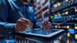 © Withun - A technician working on a tablet in a server room. The lights of the servers create a colorful backdrop.  The image represents technology and data.