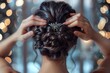 © Withun - A woman with dark hair fixes a sparkling hair pin in her elaborate updo.  The backdrop is a soft blur of lights.