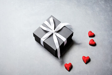 Canvas Print - Black gift box with white ribbon and red hearts on gray background