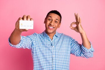 Sticker - Photo of funky cool guy dressed checkered shirt holding bank card showing okey sign isolated pink color background