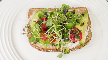 Wall Mural - Avocado, tomato, and microgreen open-faced sandwich on whole grain toast