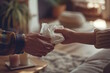 © MarGa - Hands passing tissues in a warm, cozy setting. Concept for care, support, and emotional aid during difficult times, mental health