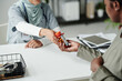 © pressmaster - Hand of young female doctor passing bottle of pills to pregnant African American patient over desk after giving advice about taking medicament