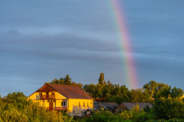 rainbow over a rural house in the mountains