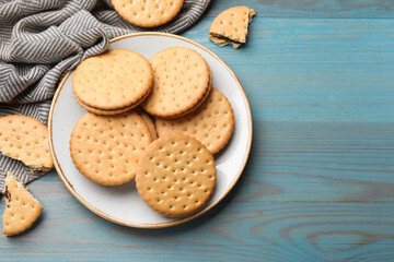 Wall Mural - Tasty sandwich cookies on light blue wooden table, top view. Space for text