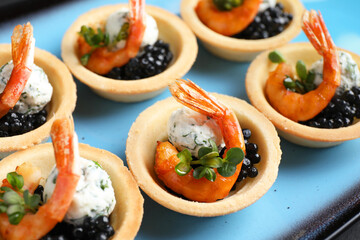 Wall Mural - Delicious canapes with shrimps and black caviar on plate, closeup