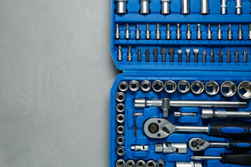 Sticker - Different auto mechanic's tools in plastic box on grey table, top view. Space for text