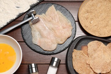 Wall Mural - Making schnitzels. Raw meat and other ingredients on wooden table, flat lay