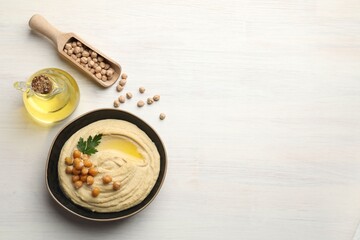 Wall Mural - Delicious hummus with olive oil, chickpeas and parsley on white wooden table, flat lay. Space for text