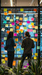 © rsimona - Team brainstorming session with sticky notes on glass wall in a modern office, ideal for mobile