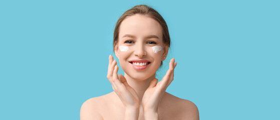 Poster - Smiling young woman with cream on blue background