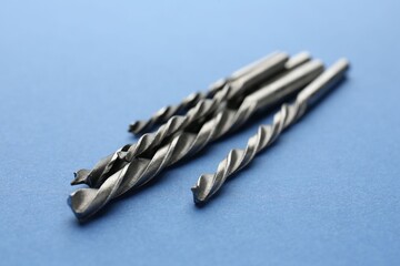 Wall Mural - Many different drill bits on light blue background, closeup