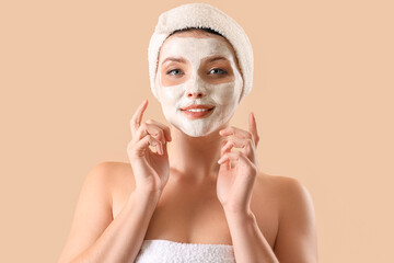 Canvas Print - Beautiful woman with applied facial mask on beige background, closeup