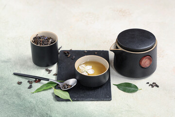 Poster - Teapot with cups, spoon of dry tea and leaves on white grunge background