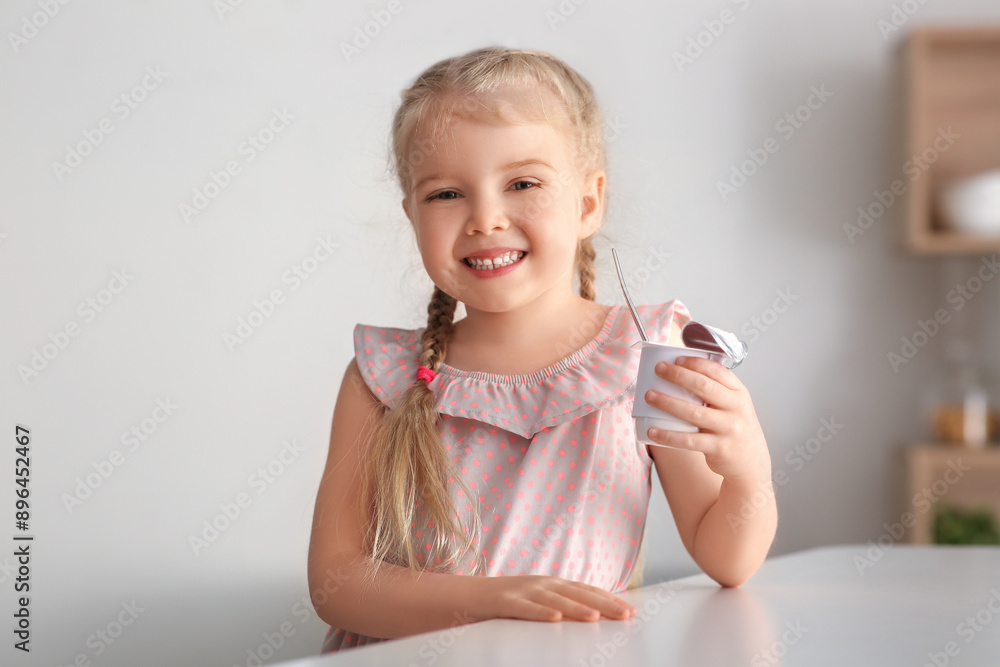 Happy little girl with yogurt at home