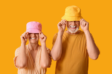 Canvas Print - Mature couple in bucket hats on yellow background