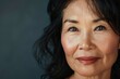 © VolumeThings - Asian middle aged woman with flawless skin promoting antiaging skincare and makeup for a radiant healthy glow Closeup with blank space