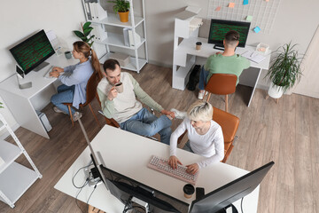 Sticker - Team of programmers working at tables in office, top view