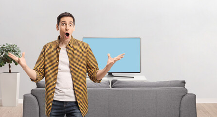 Poster - Surprised young man in front of a tv