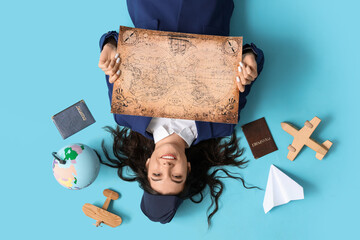 Canvas Print - Happy young stewardess with map, passports and globe lying on blue background