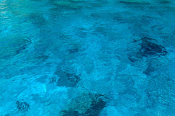 Texture of blue water under sun beams.