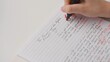 © kinomaster - Professional school or college teacher grades a homework exam papers of students. Woman grades essay test with F mark and circles it with red marker.