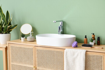 Poster - Sink with bath accessories on drawers near green wall