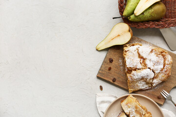 Wall Mural - Wooden board and plate with pieces of tasty pear strudel on grey background