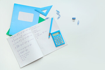 Wall Mural - Open copybook with math formulas and stationery on light background