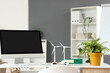 © Pixel-Shot - Engineer's workplace with computer monitor, plant and wind turbine models in office