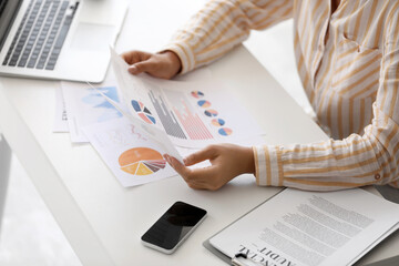 Wall Mural - Young beautiful businesswoman doing paper work at workplace with laptop in office, closeup