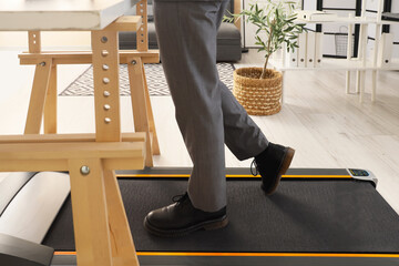 Sticker - Businessman training on treadmill at table in office