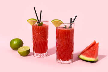 Wall Mural - Glasses of fresh watermelon juice with lime and mint on pink background