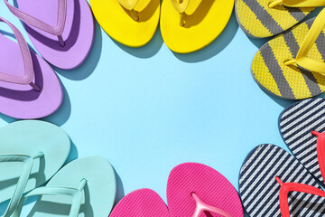 Wall Mural - Frame made of different stylish flip-flops on blue background