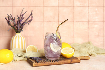 Wall Mural - Glass of fresh lavender lemonade with flowers and lemons on beige table