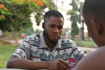 african friends playing card together, having fun