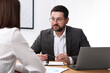 © New Africa - Consultant working with client at table in office