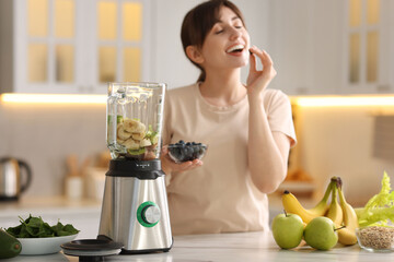 Sticker - Young woman making delicious smoothie with blender at white marble table in kitchen