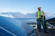 © Alan - low angle portrait of a confident engineer looking at camera, technician standing between solar panels, concept of a professional on renewable energy posing with confidence