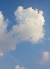 It's a blue sky with atmospheric puffy clouds.