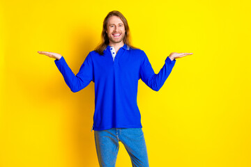 Canvas Print - Photo of attractive nice man wear trendy clothes pullover demonstrate empty space isolated on yellow color background