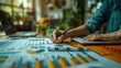 © Phichaphat - A focused person analyzes data, writing on reports filled with colorful charts and graphs in a bright workspace.